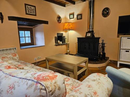 a living room with a couch and a wood stove at 14A09 Casa de la Capilla in Colunga