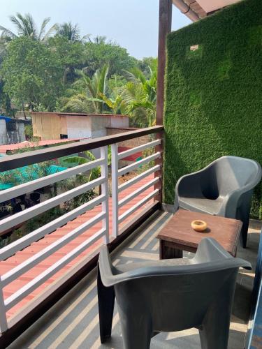a chair and a table on a balcony at YogiTree Beach Resort & Cafe - 100m from Morjim Beach in Morjim