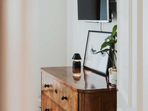 a wooden dresser with a mirror and a lamp on it at Ferienwohnung Bodenseeblick in Allensbach