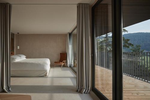 1 dormitorio con 1 cama y balcón con vistas. en Saltus en San Genesio Atesino
