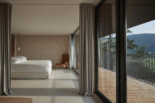 une chambre avec un lit et un balcon avec vue dans l'établissement Saltus, à San Genesio Atesino