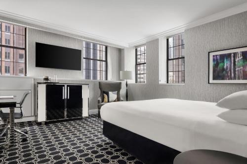 a hotel room with a large bed and a flat screen tv at The Muse New York in New York