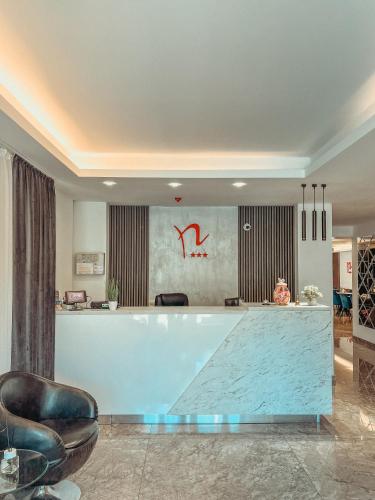 a lobby with a counter and chairs in a room at Hotel Neon in Timişoara