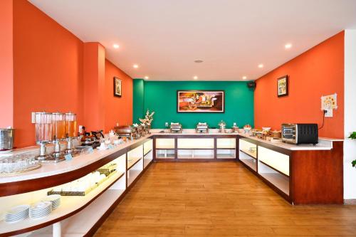 a large kitchen with orange and green walls at Nicecy Hotel - Bui Thi Xuan Street in Ho Chi Minh City