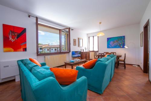 un soggiorno con divani blu e una sala da pranzo di Bardolino Garden Pool & Tennis on the lake - Happy Rentals a Bardolino