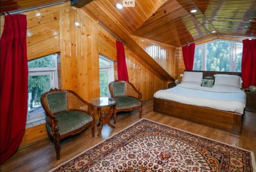 um quarto com uma cama, 2 cadeiras e uma mesa em Moonlit Mansion em Shimla