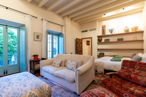uma sala de estar com um sofá e uma cama em Casa Guadalupe em Sevilha