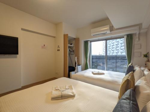 a hotel room with a bed and a window at ESLEAD HOTEL Osaka Ebisu in Osaka