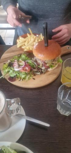 a sandwich and french fries on a wooden plate at Elle in Mablethorpe