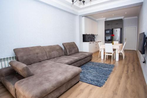 a living room with a brown couch and a table at Private Family apartment in Sumqayıt