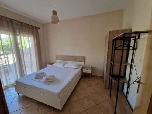 Villa Keramidi في يميناريا: غرفة نوم عليها سرير وفوط