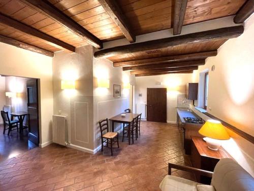 a living room with a kitchen and a table and chairs at Country House Le Case Coloniche in Deruta