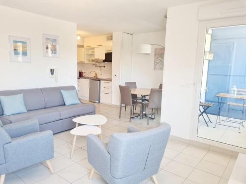 un salon avec un canapé, des chaises et une table dans l'établissement Studio à la mer avec piscine, à Sète