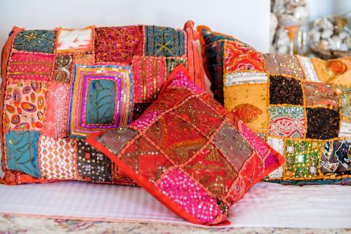 a pile of colorful pillows sitting on a bed at Conchiglia Village House in Kiotari