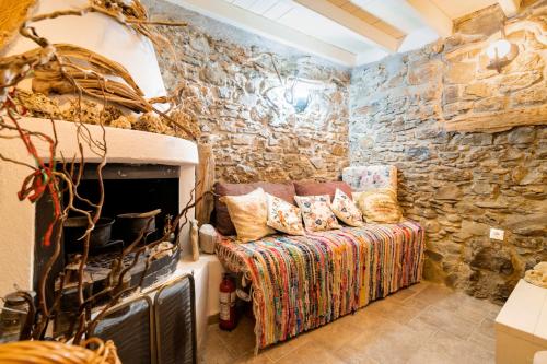 a living room with a stone wall with a couch at Conchiglia Village House in Kiotari