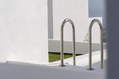 a row of three metal faucets in a bathroom at Cycladic Suites & Spa in Fira