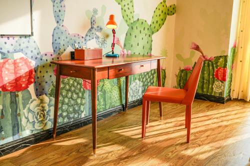 a desk with a lamp and a chair in a room at Wind sleeping Color Hotel - Free car to the Canton Fair-Line7 18Nancun Wanbo STN in Guangzhou