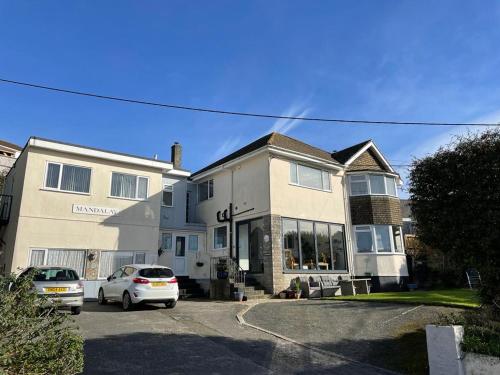 a house with cars parked in front of it at The Mandalay Guest House in Mevagissey