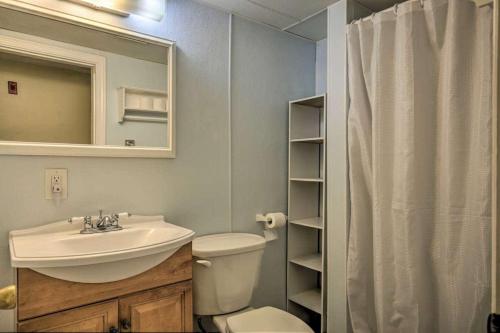 a bathroom with a sink and a toilet and a mirror at Ground Floor Unit - The Americana in Hampton