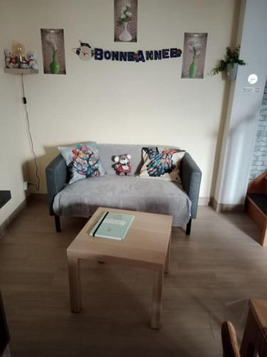 a living room with a couch and a coffee table at maison ancienne in Louviers