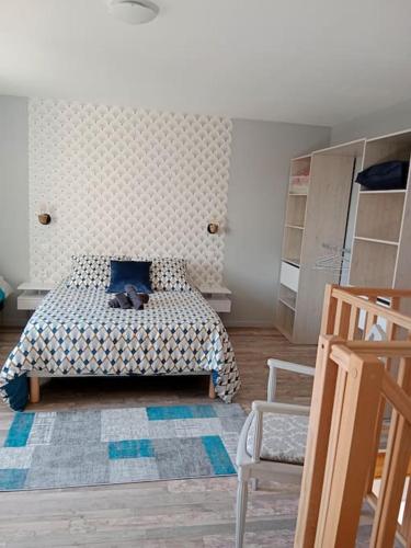 um quarto com uma cama com uma almofada azul e uma cadeira em maison ancienne em Louviers