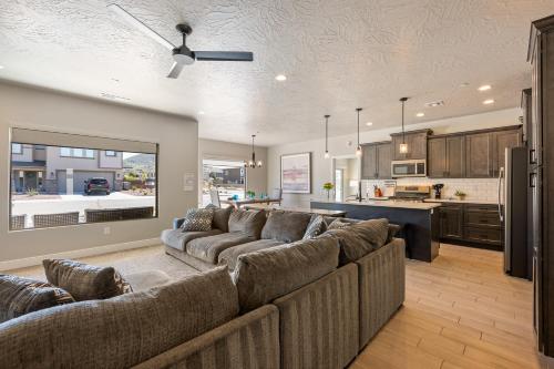 a living room with a large couch and a kitchen at Zion's Paradise townhouse in Hurricane