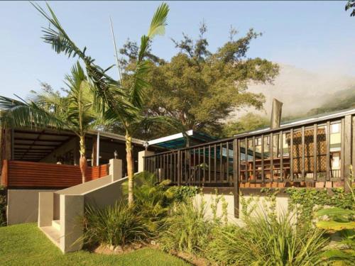 a house with palm trees in front of it at Port St Johns River Lodge in Port St Johns