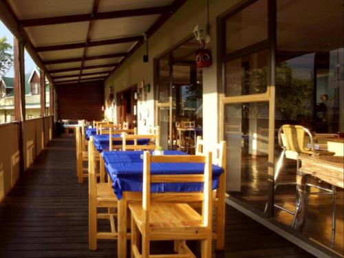 una fila de mesas en un restaurante con un mantel azul en Port St Johns River Lodge en Port Saint Johnʼs