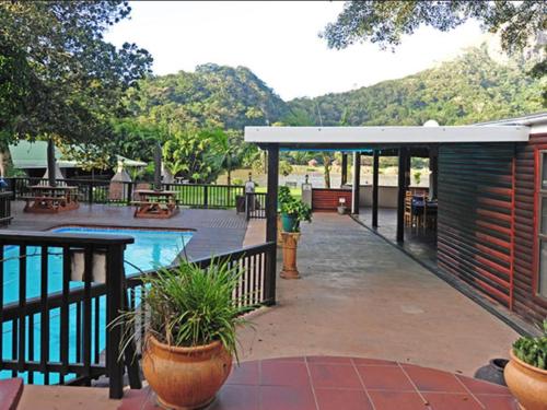 a patio with a pool and a pavilion with plants at Port St Johns River Lodge in Port St Johns