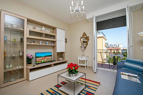 salon z niebieską kanapą i telewizorem w obiekcie Villa Mimosa Appartamento 5 - Happy Rentals w mieście Desenzano del Garda