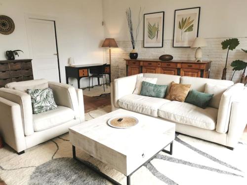 a living room with two white couches and a coffee table at Le Relais de Fleyres - Gîte Authentique avec Jardin, Parking et Wifi in Toulouse