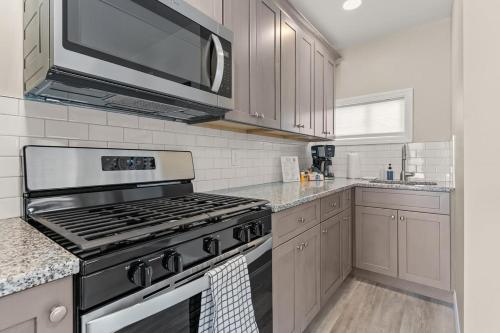 a kitchen with a stove and a microwave at Steps to Beach Fully Renovated Sleeps 6 in Hampton