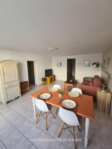 un salon avec une table, des chaises et un canapé dans l'établissement Le Nid des Epesses, aux Épesses