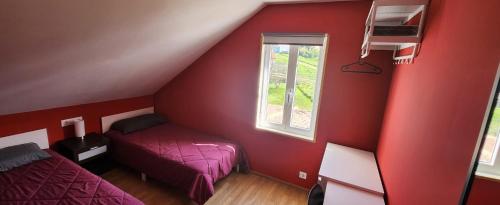 ein rotes Zimmer mit 2 Betten und einem Fenster in der Unterkunft APARTAMENTO VALDOVIÑo PEDRO in Valdoviño