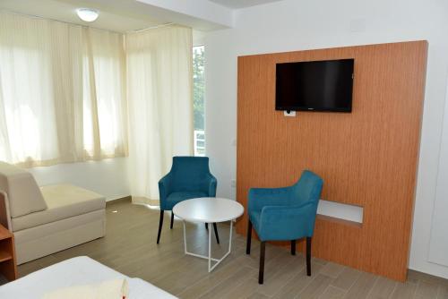 a living room with a couch and a tv on a wall at Villa Jordan in Ohrid