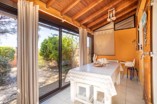 une salle à manger avec une table et une grande fenêtre dans l'établissement Maison 4 chambres fb112, au Barcarès