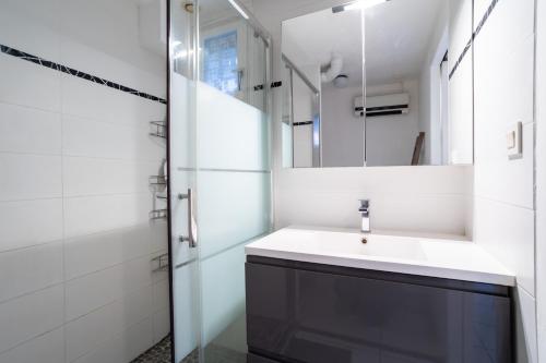 uma casa de banho com um lavatório e um espelho em Maison 4 chambres fb112 em Le Barcarès