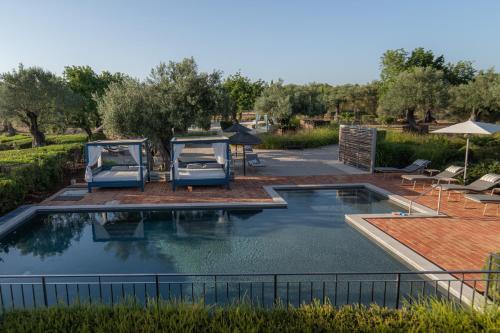 uma piscina com duas camas num quintal em Fazenda Nova Country House em Tavira