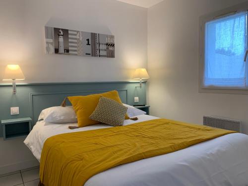 - une chambre avec un lit doté d'une couverture jaune dans l'établissement Le Petit Bois, à Sainte-Marie de Ré