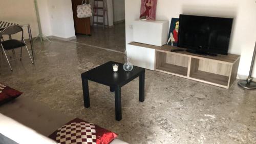 un soggiorno con TV e tavolo di Anto's apartment a San Giorgio Ionico