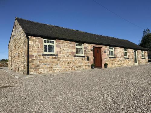 a brick building with a door on the side of it at Barn-Sleeps 4-Parking-Near Alton Towers Peak Dist in Waterfall