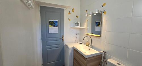La salle de bains est pourvue d'un lavabo et d'une porte bleue. dans l'établissement La Maison De La Cadière, à La Cadière-dʼAzur