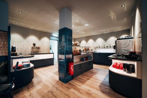 a large kitchen with black cabinets and a large stove at Hotel Zum Goldenen Hirsch in Sonthofen