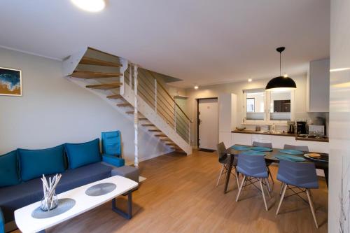 Il comprend un salon avec un canapé bleu et une cuisine. dans l'établissement Apartamenty Kajan, à Jastrzębia Góra