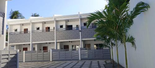 a building with a palm tree in front of it at Kings'Palms Residence01 in General Santos