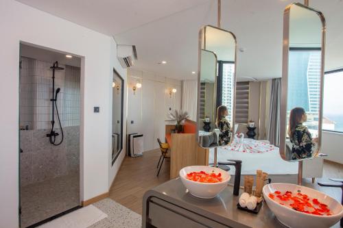 a bathroom with two bowls on a counter and a woman in a mirror at PĀMA Boutique Hotel & Bistro in Da Nang