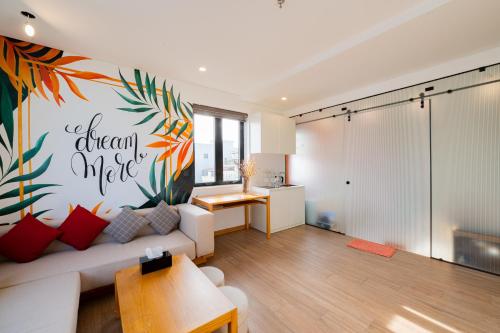 a living room with a couch and a painting on the wall at PĀMA Boutique Hotel & Bistro in Da Nang