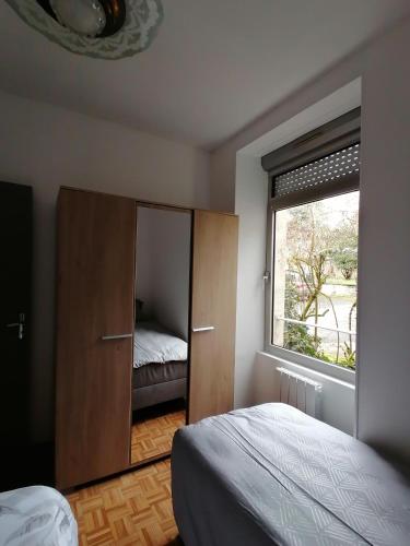 une chambre avec un lit et une grande fenêtre dans l'établissement Appartement-Vierzon-centre, à Vierzon