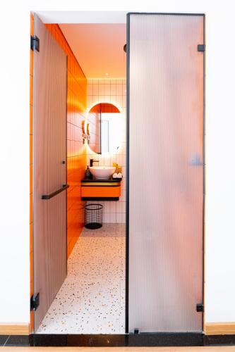 a bathroom with a door open to a bathroom with a sink at PĀMA Boutique Hotel & Bistro in Da Nang