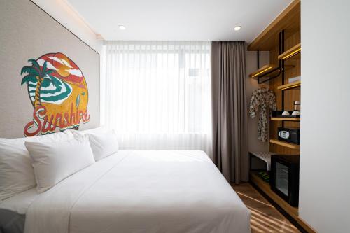 a bedroom with a large white bed in a room at PĀMA Boutique Hotel & Bistro in Da Nang